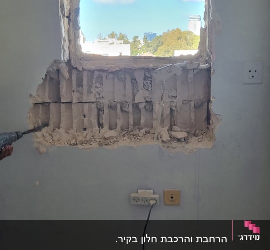 חור בקיר עם פסולת בנייה על הרצפה